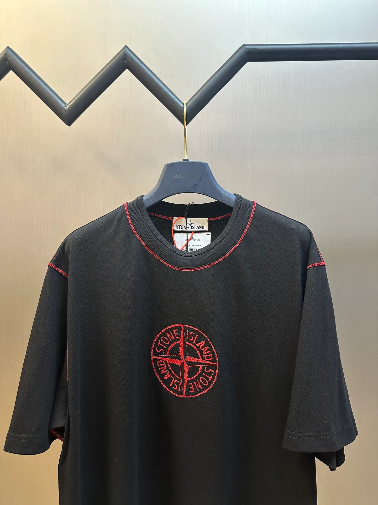 🅿️270 Stonelsland Badge Embroidered Short Sleeves Customized elegant black silk cotton and linen plain fabric, with iconic red Compass badge embroidery on the chest, stitching art, and the beauty of contrasting colors. The red stitches jump on the black base. The collision of fashion and creativity exudes irresistible charm. Imported machine embroidery technology is used, and advanced computer control systems and precision mechanical components are used to realize the red Compass badge embroidery operation. Special machine for reverse topstitching and fine sewing process. Special machine is used for topstitch sewing. It requires careful preparation of the reverse side of the garment before sewing to ensure that the sewing lines are straight, the stitches are even, and the edges are smooth and beautiful.  size：s m l xl